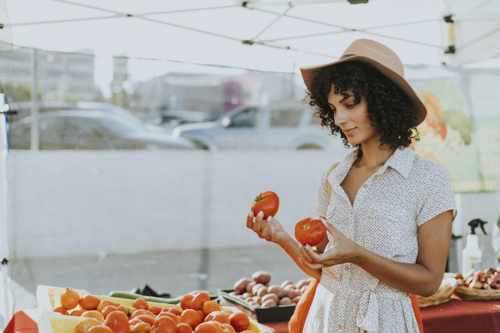 Woman Buying Tomatoes At A Farmers Market 5GUKW84 1024x683 